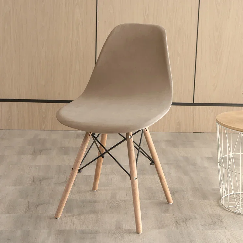 Scandinavische kuipstoel met taupe fluwelen hoes in een interieur met houten wand